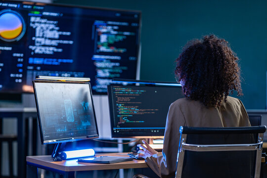 Brazilian cybersecurity expert conducting a real time threat assessment and debugging system vulnerabilities on a large scale AI monitoring display.