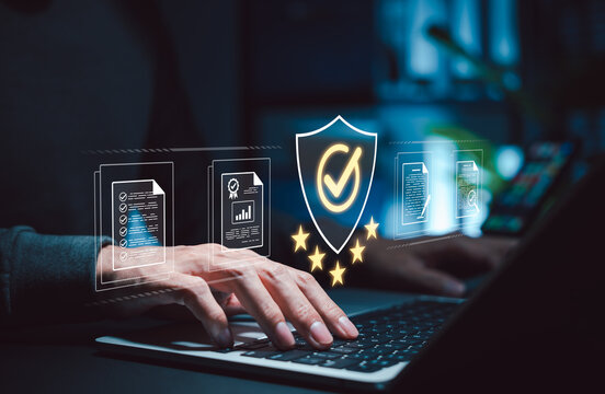 Quality assurance and compliance audit concept. Businessman using laptop and shield checkmark, reviewing documents, verification reports, certification, risk control, governance and approval workflow