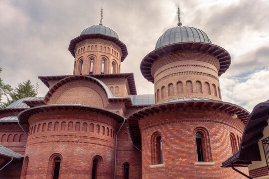 Close view of red brick domes and crosses at Curtea de Arges Monastery in Arges County, Romania