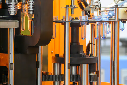 PET preforms moving on conveyor belt to blow molding machine for bottle mass production