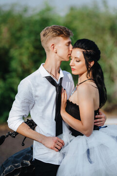 A couple of newlywed freaks on a black custom bike