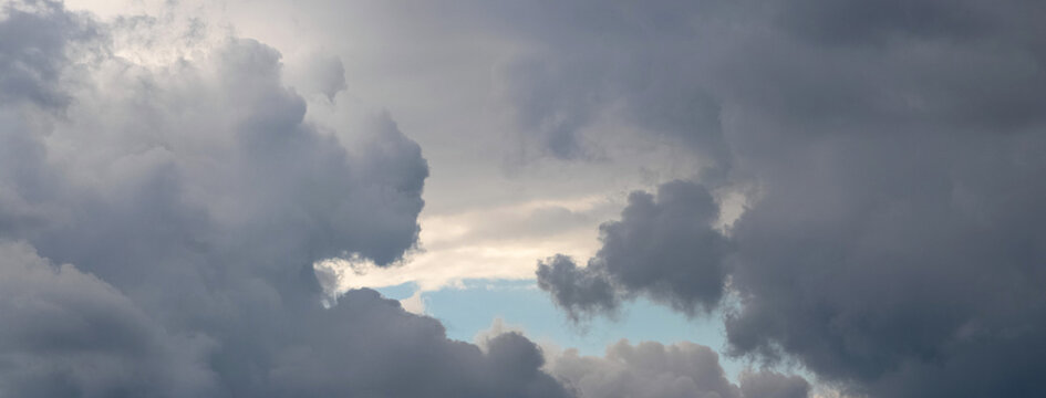 Massive storm clouds with glimpse of blue sky between them