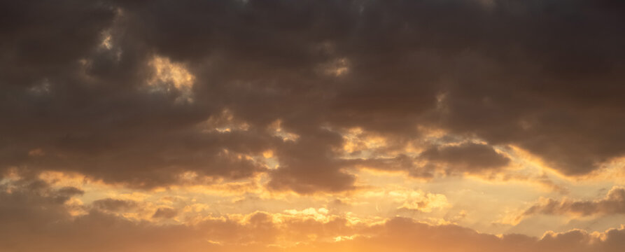 Dramatic sky with golden clouds during vivid sunset