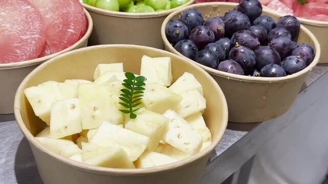  Assorted sliced fresh fruits in paper bowls watermelon grapes pomelo vertical HD