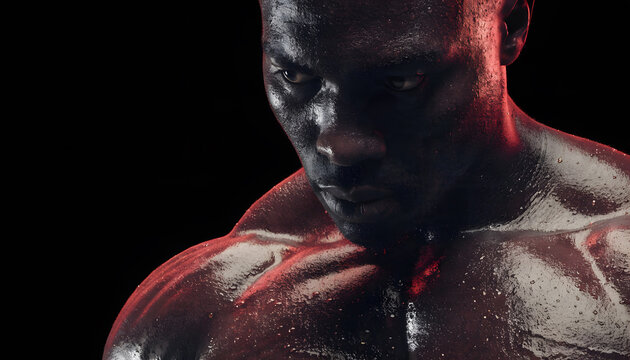 Intense male athlete portrait focusing during heavy workout. Sweaty skin texture and athletic determination. Close up of a muscular black man glaring with intense focus