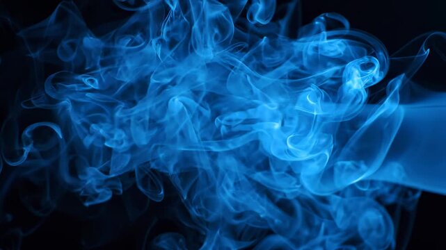 Abstract blue smoke gracefully moving and expanding against a deep black backdrop, forming intricate and fluid designs.