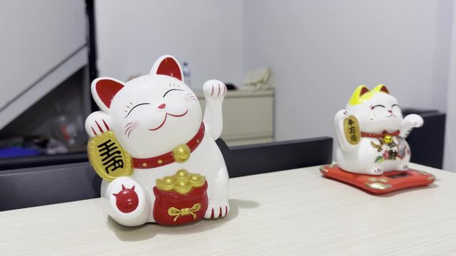Traditional Chinese lucky cat statue, also known as Maneki-neko, with a moving paw, displayed as a symbol of good luck, prosperity, fortune, and wealth in  Asian culture