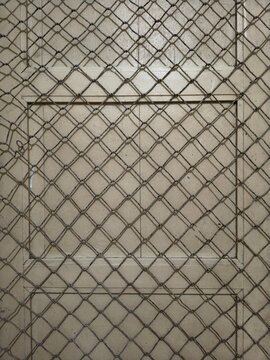 Full frame pattern of rope net texture in front of an old wooden door