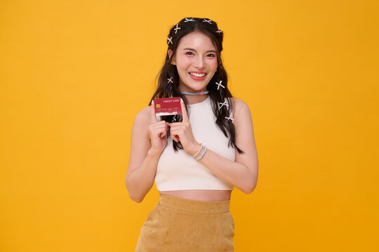 Young woman holding credit card and smiling representing cashless payment online shopping personal finance consumer confidence digital banking purchasing power and modern lifestyle.