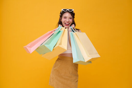 Shopping woman holding colorful bags and smiling expressing retail therapy consumer happiness shopping spree seasonal sale purchasing confidence fashion lifestyle and customer experience.