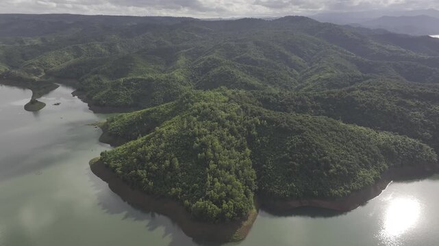 Aerial drone view of Ta Dung Lake surrounded by hundreds of green island hills and mountains in Ta Dung Commune, Lam Dong Province, Vietnam. View from QL 28. D Log mode