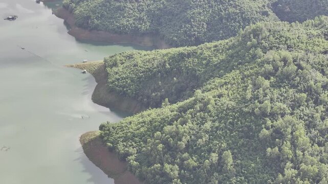 Aerial drone view of Ta Dung Lake surrounded by hundreds of green island hills and mountains in Ta Dung Commune, Lam Dong Province, Vietnam. View from QL 28. D Log mode