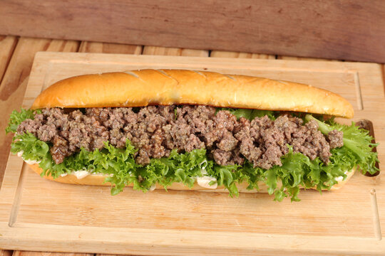sanduiche recheado no p&atilde;o tipo brioche com salada, carne e queijo