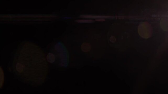 Abstract light leaks and lens flare creating a dynamic visual with vibrant bokeh circles and glowing effects.