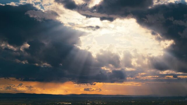 Time lapse of a dramatic sky and sun burst with beams of light breaking through the moving clouds 