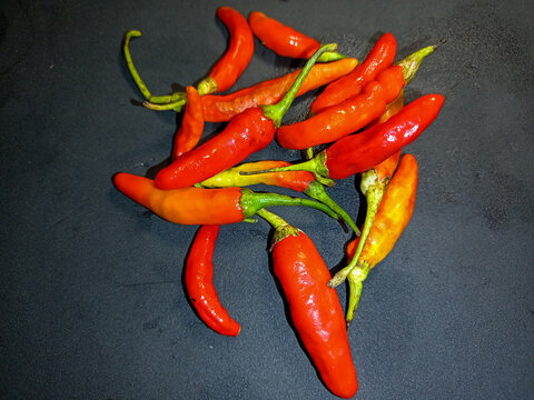 red hot chili peppers. A small pile of fresh bird's eye chili peppers, known locally in Indonesia as cabe rawit