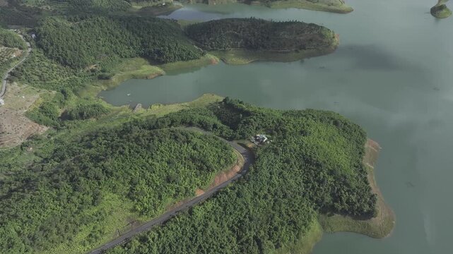 Aerial drone view of Ta Dung Lake surrounded by hundreds of green island hills and mountains in Ta Dung Commune, Lam Dong Province, Vietnam. View from QL 28. D Log mode