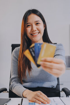 Young Asian business woman using smartphone and credit card for online shopping. Online Payment.