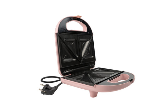 An open pink sandwich toastie maker is shown from a side angle, revealing its triangle plates, handle cutout, and cord on white background.