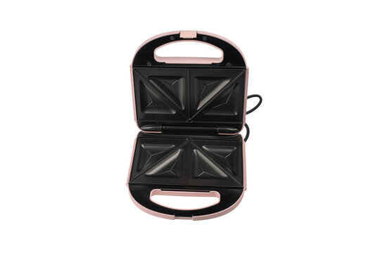 An open pink sandwich toastie maker is viewed from directly above, showing both sets of black triangle plates in symmetrical framing.
