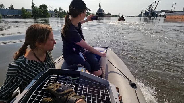 Volunteers sail on boat to evacuate animals and people after detonation of Hydroelectric Power Station. Flooding in Kherson as result of explosion of dam on Dnipro river in city of Novaya Kakhovka