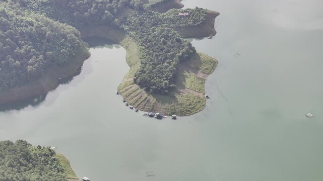 Aerial drone view of Ta Dung Lake surrounded by hundreds of green island hills and mountains in Ta Dung Commune, Lam Dong Province, Vietnam. View from QL 28. D Log mode