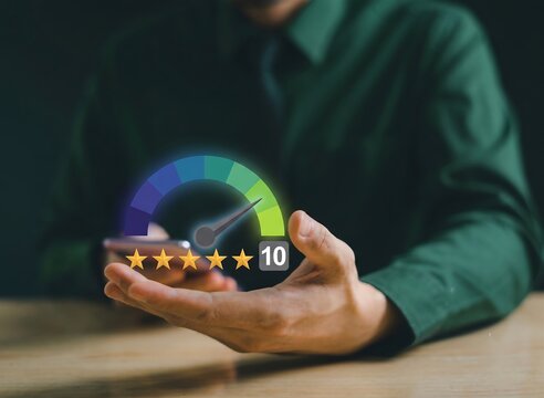 Businessman hand holding smartphone with virtual five star rating and maximum score gauge hologram