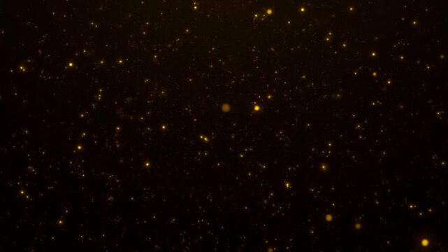 Golden dust particles floating in space. Abstract shimmering bokeh lights moving slowly on a black background. High quality cinematic b-roll for luxury and celebration themes.