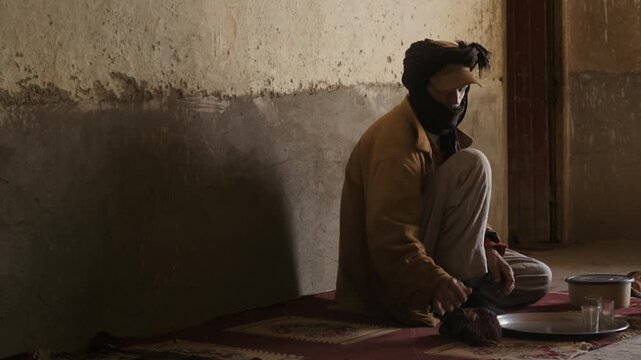 Middle eastern man performing the islamic purification ritual of wudu before praying on a rug