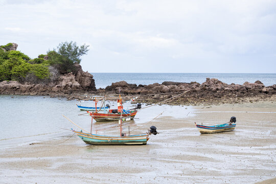 Fishing boats resting in shallow coastal bay at low tide