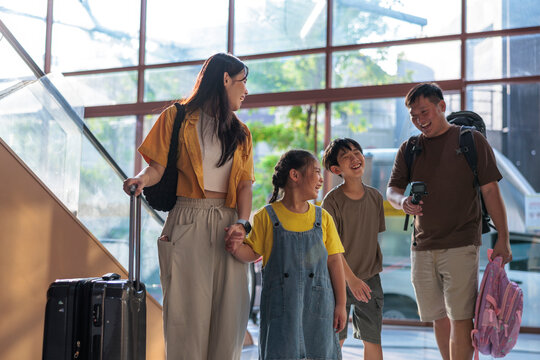 A happy family laughing while traveling at the airport.
