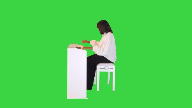 Inspired african american girl plays the electric piano, stops and smiles in the end on a Green Screen, Chroma Key.