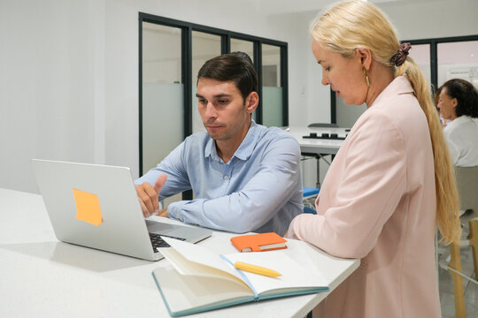 Business team reviewing work on laptop together