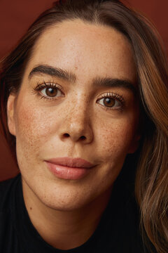 Young woman face with natural freckles smiling