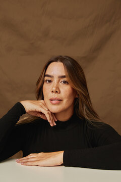 Woman with freckles posing in warm neutral tones