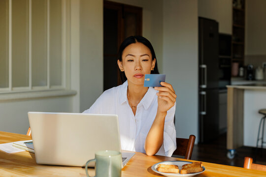 Woman doing online shopping using credit card at home