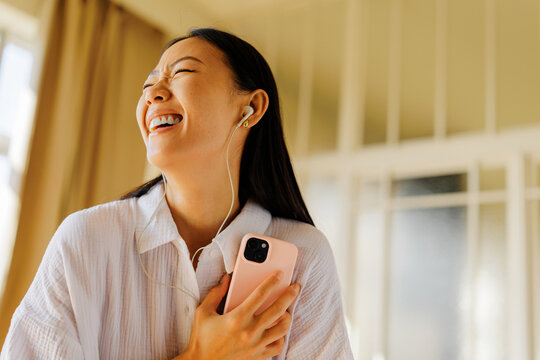 Woman enjoying music with headphones smiling genuinely