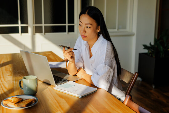 Woman thinking while working remotely at home
