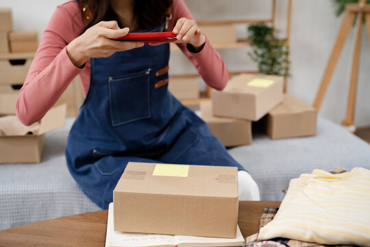 Female entrepreneur packing online orders at home