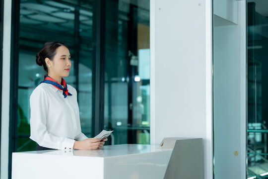 Airport staff assists a smiling passenger with travel documents at a modern check-in counter representing efficient service and a smooth journey.