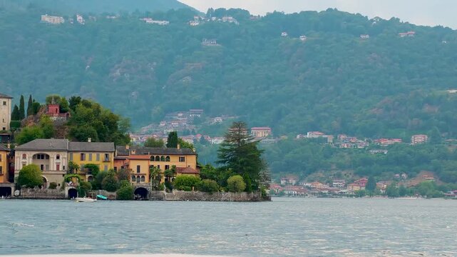 San Giulio Island on Lake Orta, Piedmont, Italy. Aerial 4K video footage featuring the historic basilica and picturesque lakeside scenery surrounded by Alpine landscapes