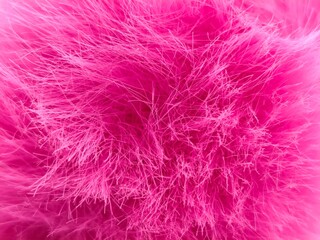 Obraz premium Background view of vibrant hot pink faux fur featuring soft, densely packed fuchsia fibers and a rich neon magenta tone, creating a luxurious, cozy abstract plush texture.