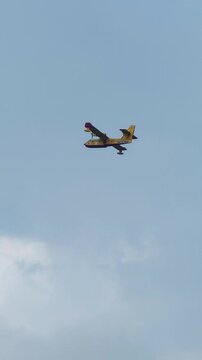Firefighting Canadair aircraft flying over Italian lake during large forest wildfires, preparing to scoop water, supporting aerial firefighting operations and wildfire suppression in Europe. 4K video
