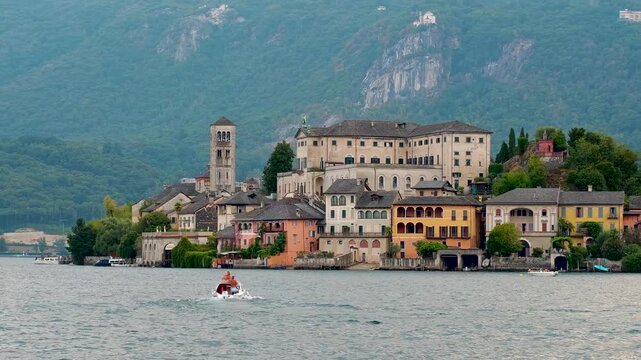 San Giulio Island on Lake Orta, Piedmont, Italy. Aerial 4K video footage featuring the historic basilica and picturesque lakeside scenery surrounded by Alpine landscapes
