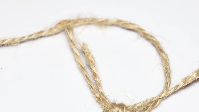 A detailed view of a rope lying on a table, suitable for use in a variety of settings, such as interior design, photography, or crafting. Rotating in a circle