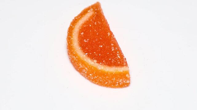 A close-up of a half orange with a thick layer of sugar covering its surface. Rotating in a circle