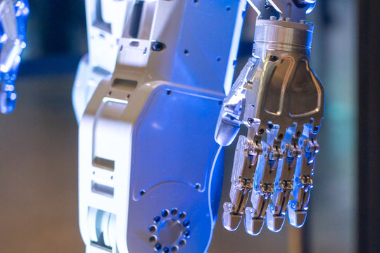 Closeup of metal robot hand. Concept of modern technology. Blue tone