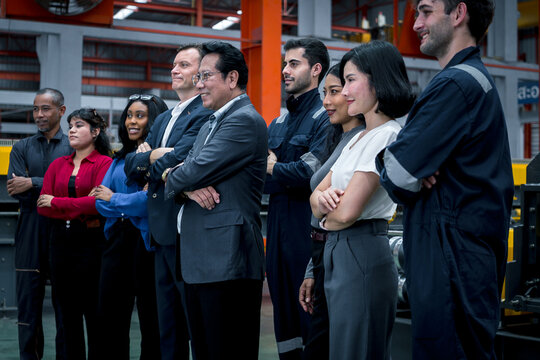 Industrial teamwork and leadership. Diverse business professionals and factory staff stand together inside a manufacturing plant. Industry, teamwork, leadership, workforce, factory