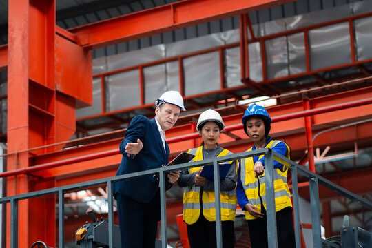 Industrial leadership and factory inspection. Engineers and managers review production operations on a manufacturing platform. Leadership, inspection, industry, teamwork, manufacturing