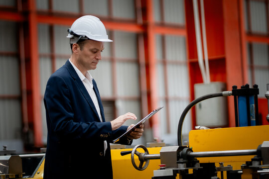 Caucasian professional Engineer factory. Engineering worker in safety hardhat at factory industrial facilities. Heavy Industry Manufacturing Factory
